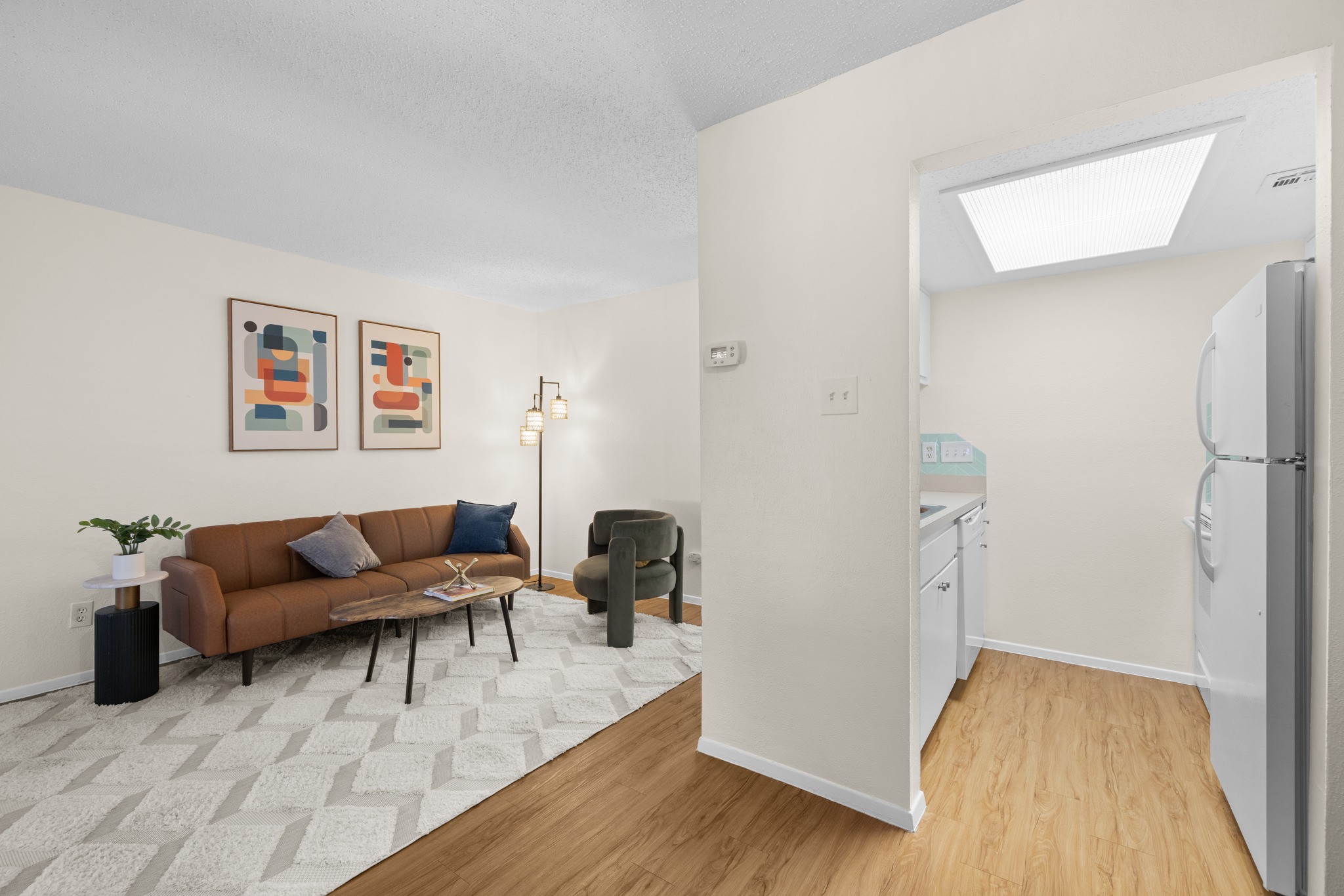 9079 Jollyville Road, Unit 301 Austin, TX 78759 - Photo 14 of 38 #103 An inviting living area with rich wood-look flooring seamlessly connects to a compact, well-equipped kitchen space.