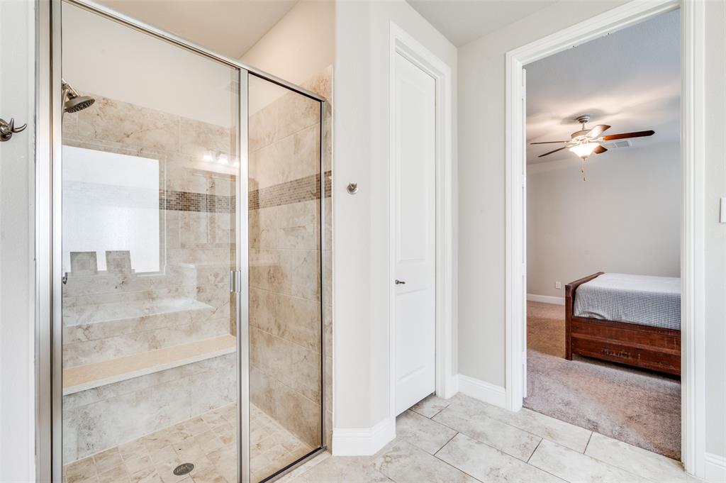 6117 Hall Road Frisco, TX 75034 - Photo 14 of 32 Ensuite bathroom featuring a shower stall, a ceiling fan, light tile patterned floors, and light carpet