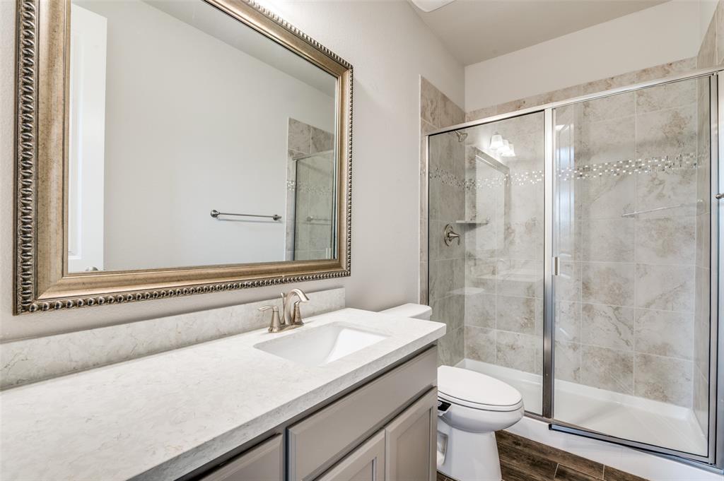 6117 Hall Road Frisco, TX 75034 - Photo 18 of 32 Bathroom with vanity, a shower stall, and dark wood-style flooring