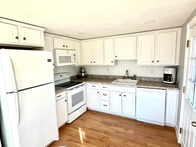 a kitchen with white cabinets and white appliances