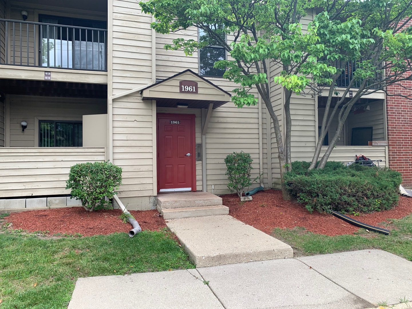 a front view of a house with a yard and potted plants