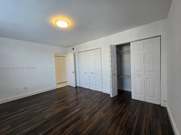 a view of empty room with wooden floor and window