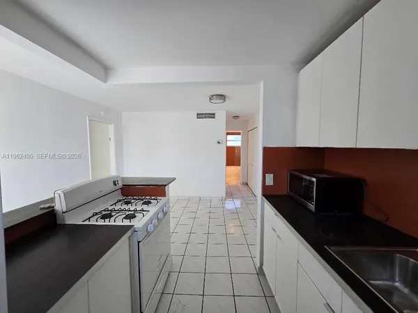a kitchen with granite countertop a stove and a refrigerator