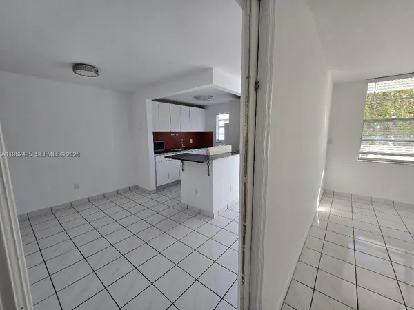 a view of a kitchen with white cabinets and a sink
