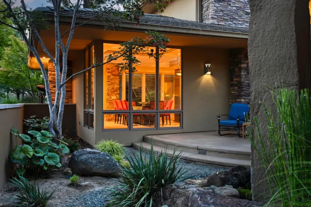 a view of a house with a garage and large trees