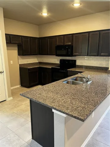 a kitchen with a sink and a stove top oven
