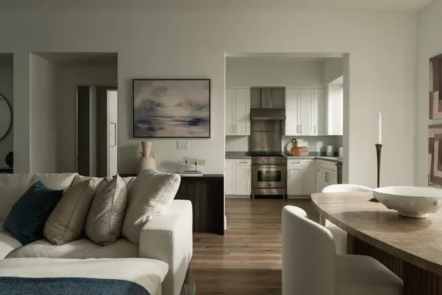 a living room with furniture and kitchen