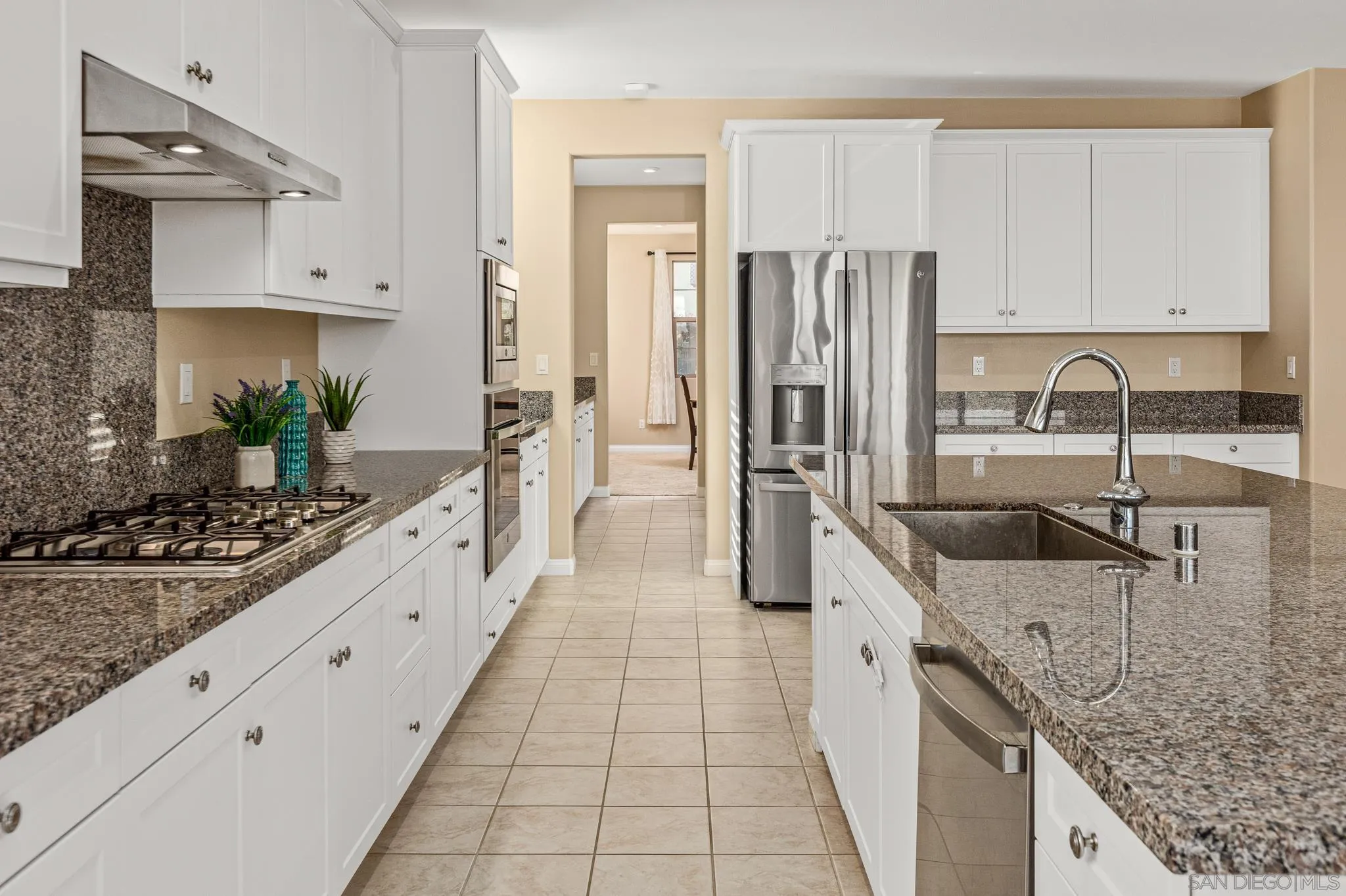 2401 Monroe Place Escondido, CA 92027 - Photo 7 of 23 a large kitchen with kitchen island granite countertop a large counter top stainless steel appliances and cabinets