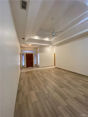 an empty room with wooden floor fireplace and windows