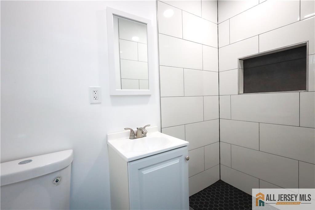 397 Washington Street Perth Amboy, NJ 08861 - Photo 5 of 8 a bathroom with a sink toilet and shower