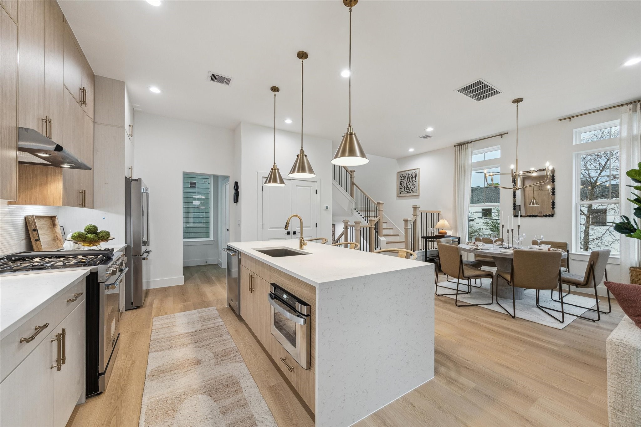 752 Curtin Street Houston, TX 77018 - Photo 14 of 37 Discover a bright open-concept kitchen and dining area featuring sleek cabinetry, modern light fixtures, and a spacious island, perfect for entertaining.