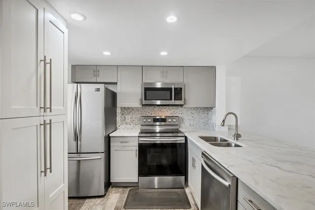 a kitchen with stainless steel appliances a refrigerator stove and microwave