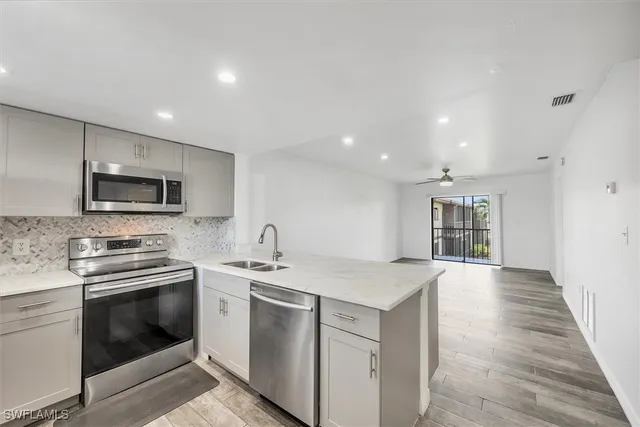 a kitchen with a sink white cabinets and stainless steel appliances