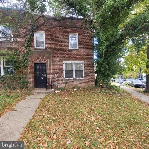 a view of a brick house with many windows and trees