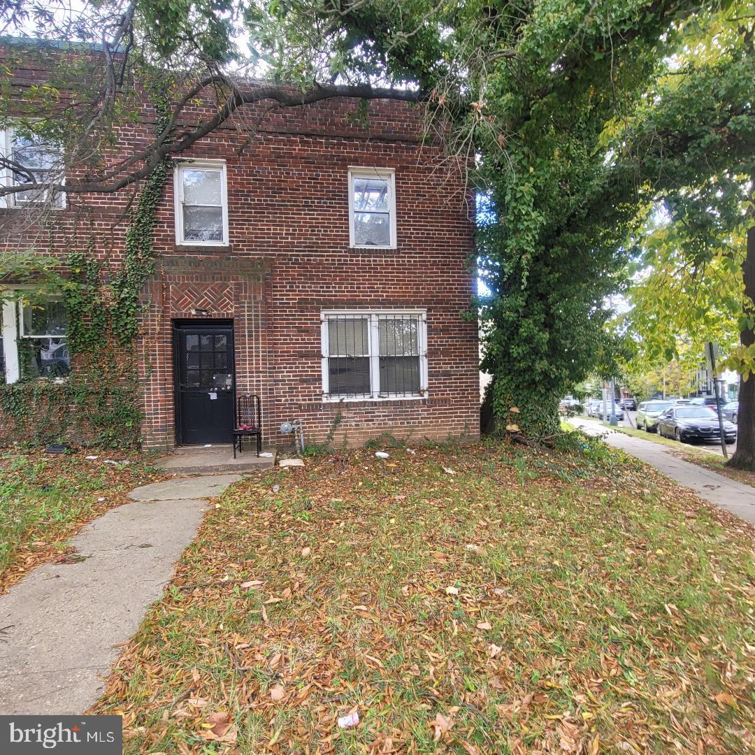 a view of a brick house with many windows and trees