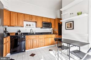 2 Hamlet Hill Road Baltimore, MD 21210 - Photo 6 of 25 a kitchen with stainless steel appliances granite countertop a stove top oven a sink a dining table and chairs with the front door