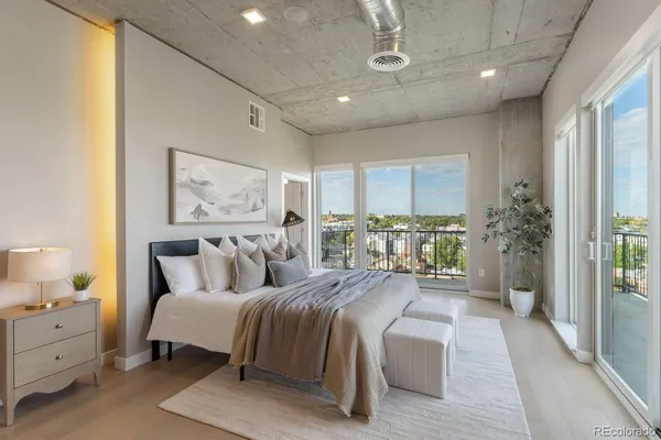 a bedroom with a large bed and a balcony next to a window