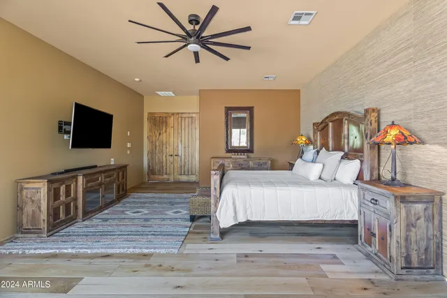 a bedroom with a bed and a flat screen tv