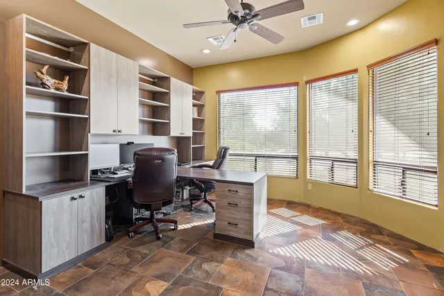 a view of a workspace with furniture and a window