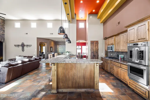 a kitchen with stainless steel appliances kitchen island granite countertop a stove and cabinets