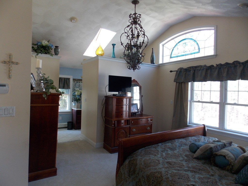 79 Haverhill Road Amesbury, MA 01913 - Photo 17 of 25 a bedroom with a bed and a chandelier