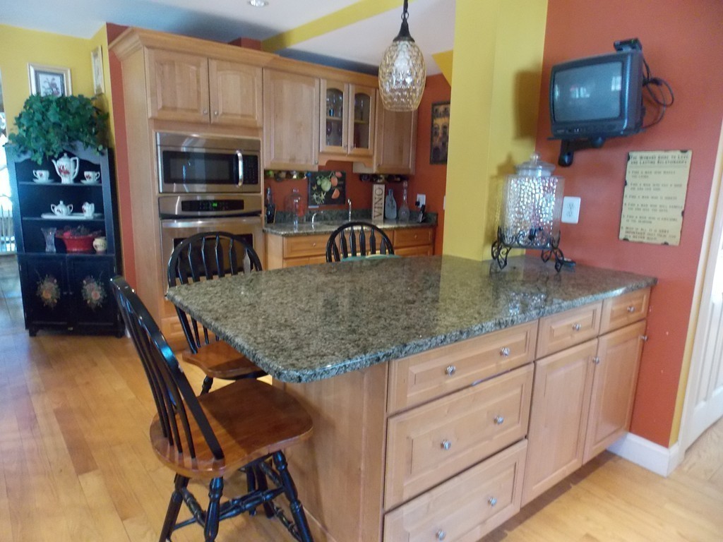 79 Haverhill Road Amesbury, MA 01913 - Photo 7 of 25 a kitchen with granite countertop a table chairs microwave and sink