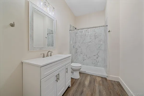 a bathroom with a sink a toilet and shower