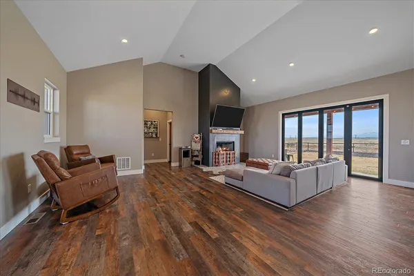 a living room with fireplace furniture and a wooden floor