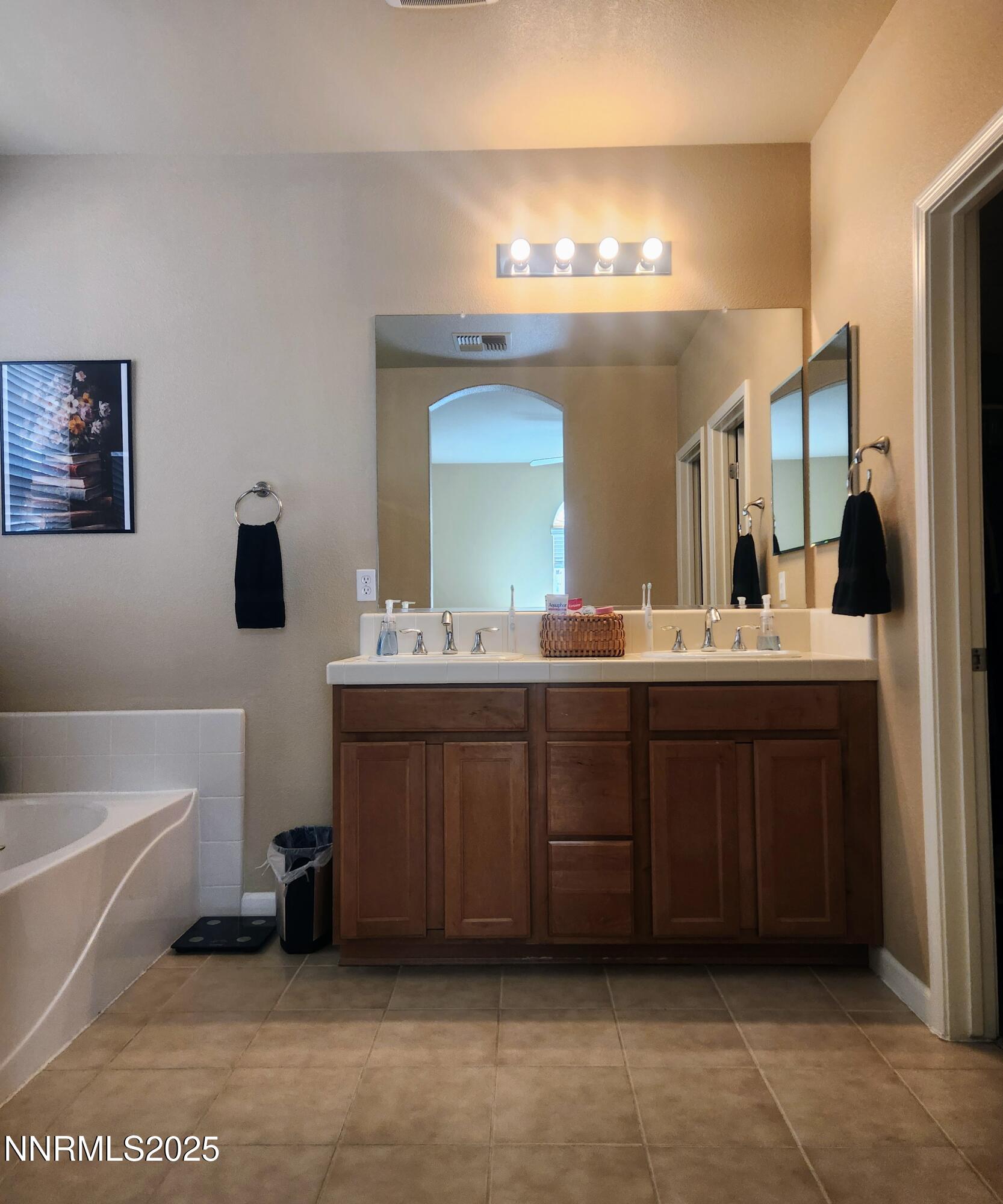 1828 Wind Ranch Road, Unit C Reno, NV 89521 - Photo 5 of 6 a bathroom with a double vanity sink a mirror and bathtub