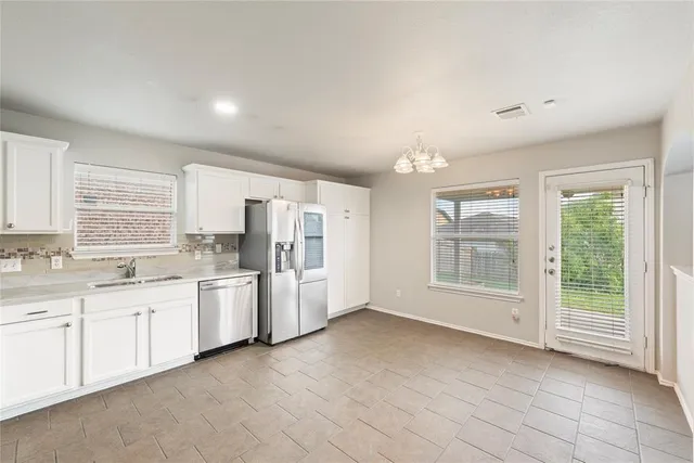 a large white kitchen with a large window