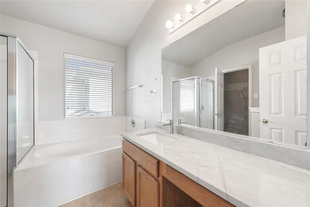 a bathroom with a tub a sink and a window