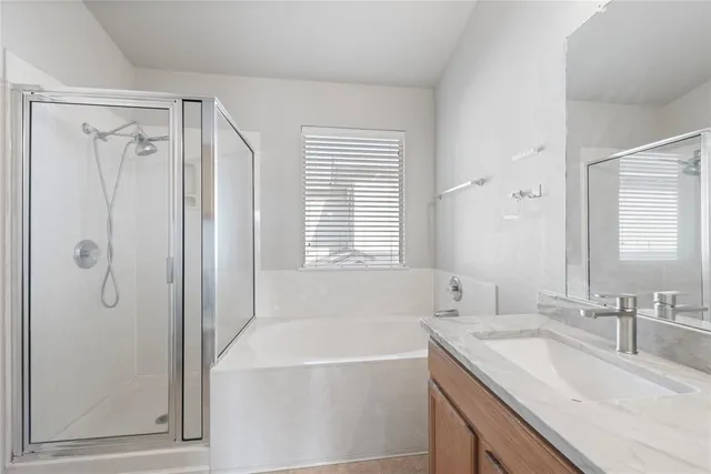 a bathroom with a granite countertop sink mirror and a bathtub