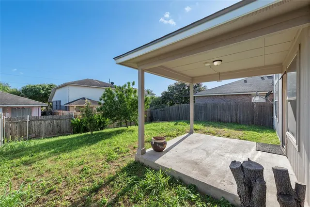a view of backyard with small cabin and wooden fence