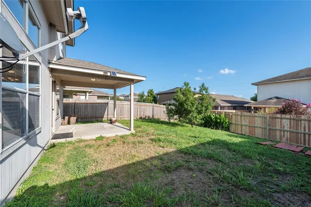 a view of a backyard with plants and wooden fence