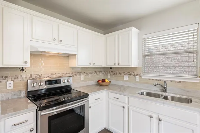 a kitchen with cabinets appliances a sink and a window
