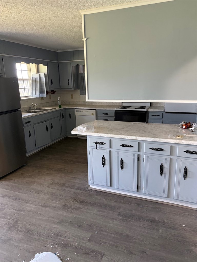 618 Madden Road Jacksonville, AR 72076 - Photo 11 of 34 Kitchen featuring an island with light-toned countertops, gray cabinetry with black hardware, and wood-finish flooring