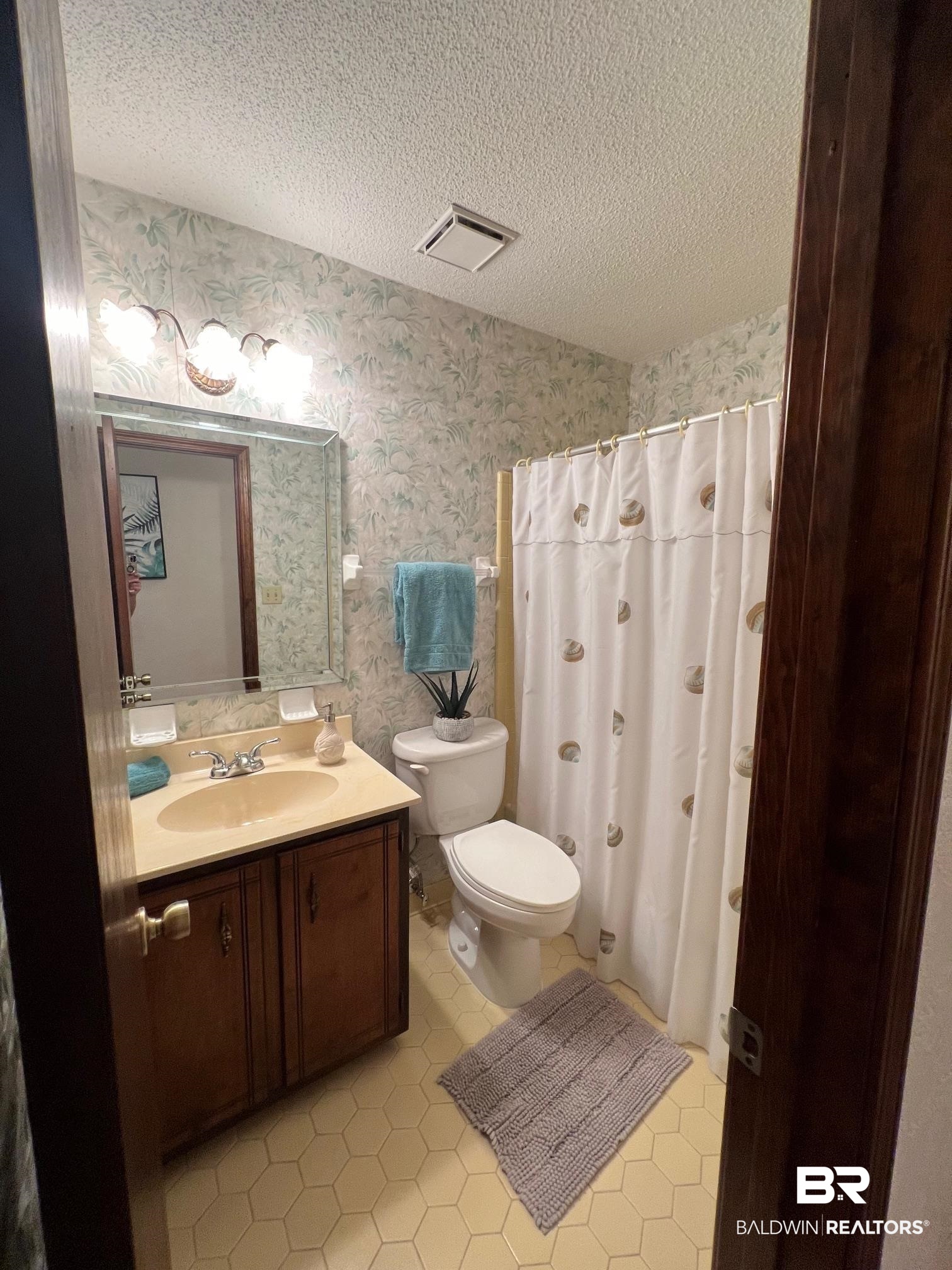 2240 Perdido Circle Lillian, AL 36549 - Photo 19 of 42 Bathroom featuring vanity, tile patterned flooring, toilet, and a textured ceiling