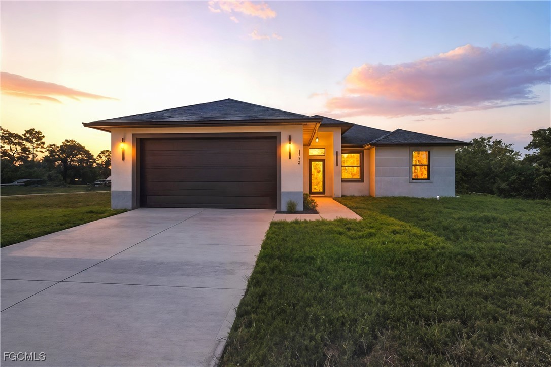 a front view of a house with a yard and garage