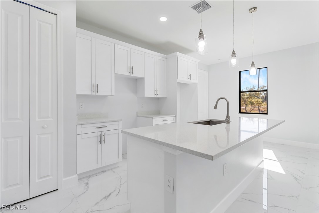 1152 Randolph Street Lehigh Acres, FL 33974 - Photo 12 of 50 a kitchen with white cabinets and sink