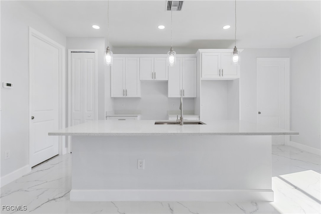 1152 Randolph Street Lehigh Acres, FL 33974 - Photo 13 of 50 a view of kitchen with a sink wooden cabinets and glass door