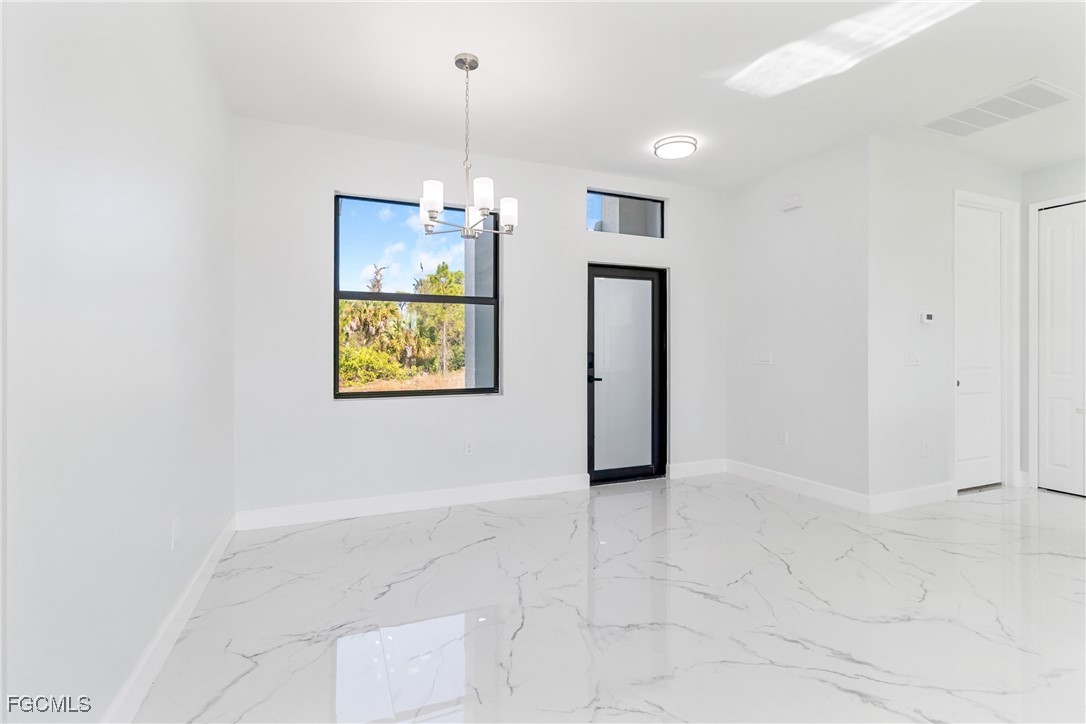 1152 Randolph Street Lehigh Acres, FL 33974 - Photo 16 of 50 a view of an empty room with window and chandelier fan