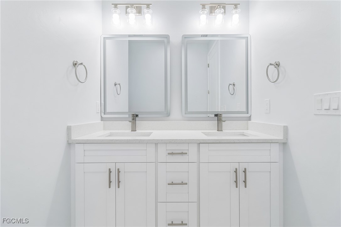 1152 Randolph Street Lehigh Acres, FL 33974 - Photo 20 of 50 a bathroom with double sink and a mirror