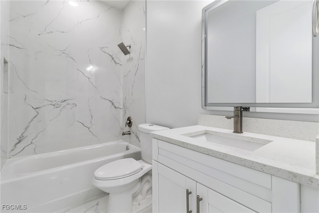 1152 Randolph Street Lehigh Acres, FL 33974 - Photo 22 of 50 a bathroom with a sink a toilet and a bathtub