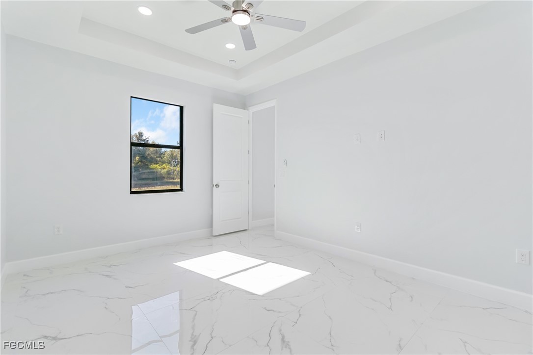 1152 Randolph Street Lehigh Acres, FL 33974 - Photo 24 of 50 an empty room with a chandelier fan and windows