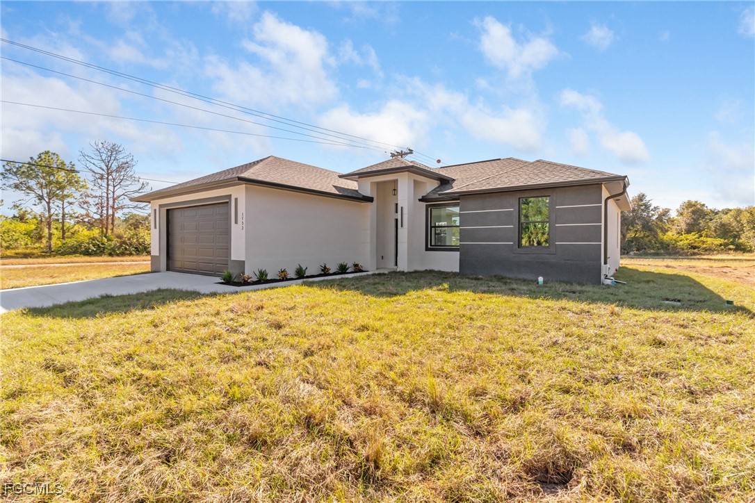 1152 Randolph Street Lehigh Acres, FL 33974 - Photo 50 of 50 a front view of house with yard and trees in the background