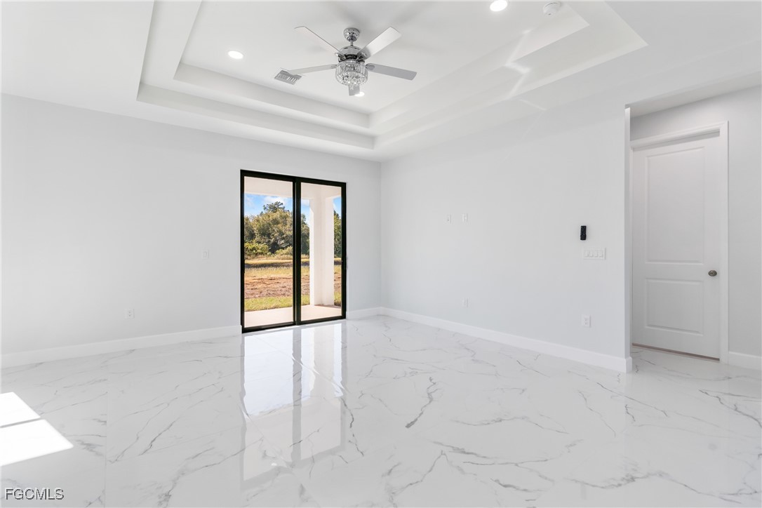 1152 Randolph Street Lehigh Acres, FL 33974 - Photo 7 of 50 an empty room with chandelier fan and windows