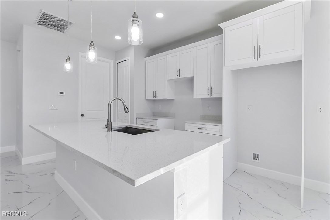 1152 Randolph Street Lehigh Acres, FL 33974 - Photo 10 of 50 a kitchen with a sink a stove and cabinets