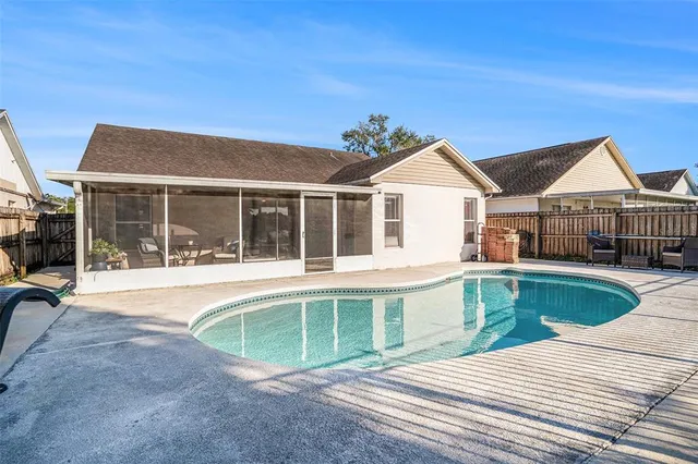 a view of a house with a swimming pool and sitting area