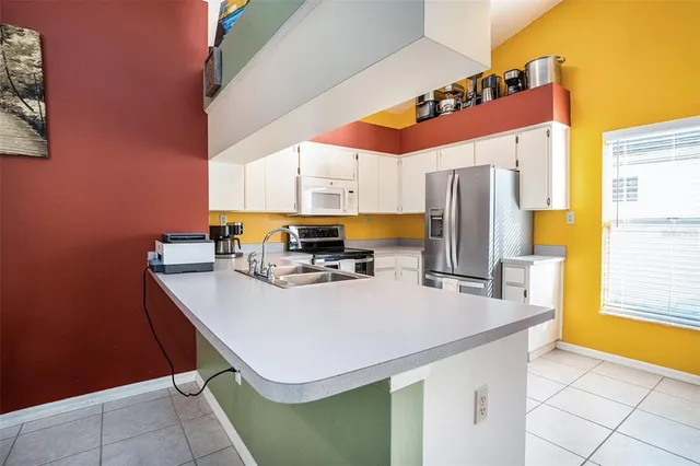 a kitchen with stainless steel appliances a sink a counter top space and cabinets