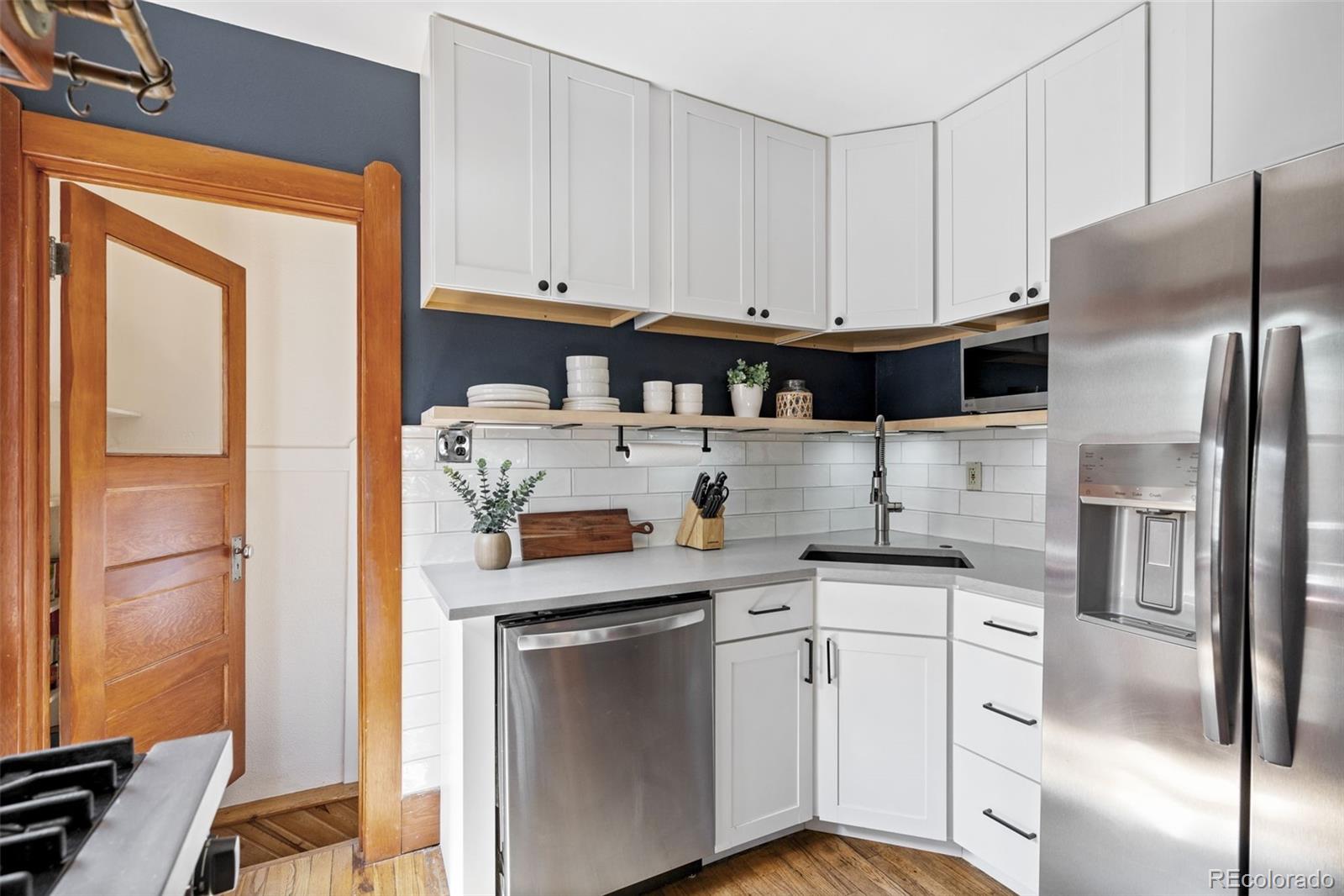1247 Harrison Street Denver, CO 80206 - Photo 13 of 50 a kitchen with stainless steel appliances a refrigerator sink and cabinets